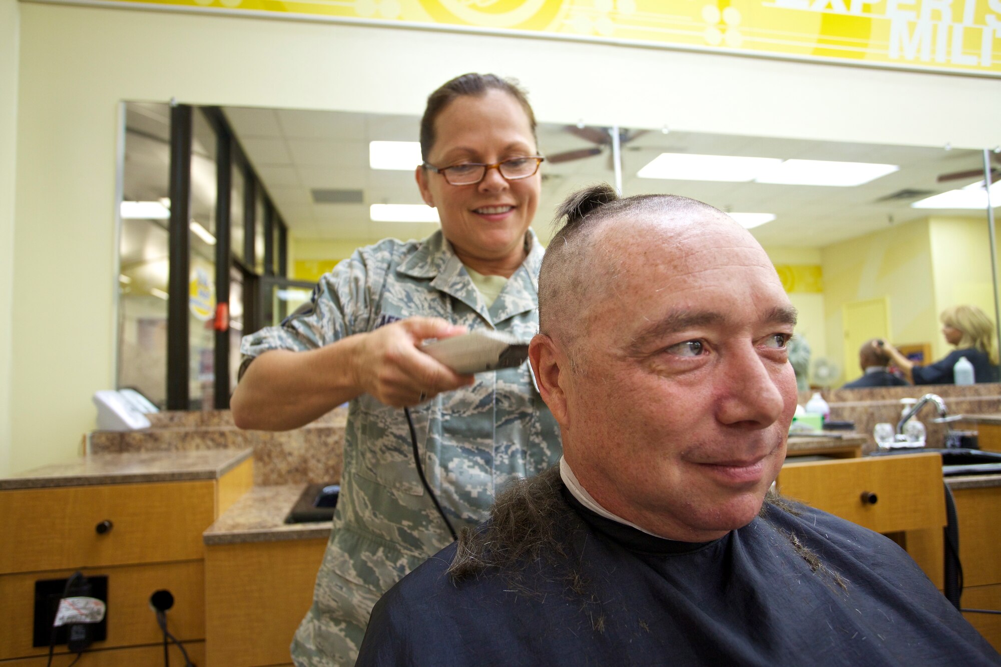TYNDALL AIR FORCE BASE, Fla. -- When members of the Air Force Civil Engineer Center’s Force Development Division shaved their heads recently in support of a fellow Airman dealing with cancer, some of them didn’t have much hair to begin with.  Senior Master Sgt. Spencer Emanuels, on the other hand, had a full head of nice thick locks. Senior Master Sgt. Michelle Lafferty had fun helping him get rid of all of it. (U.S. Air Force photo/Eddie Green)