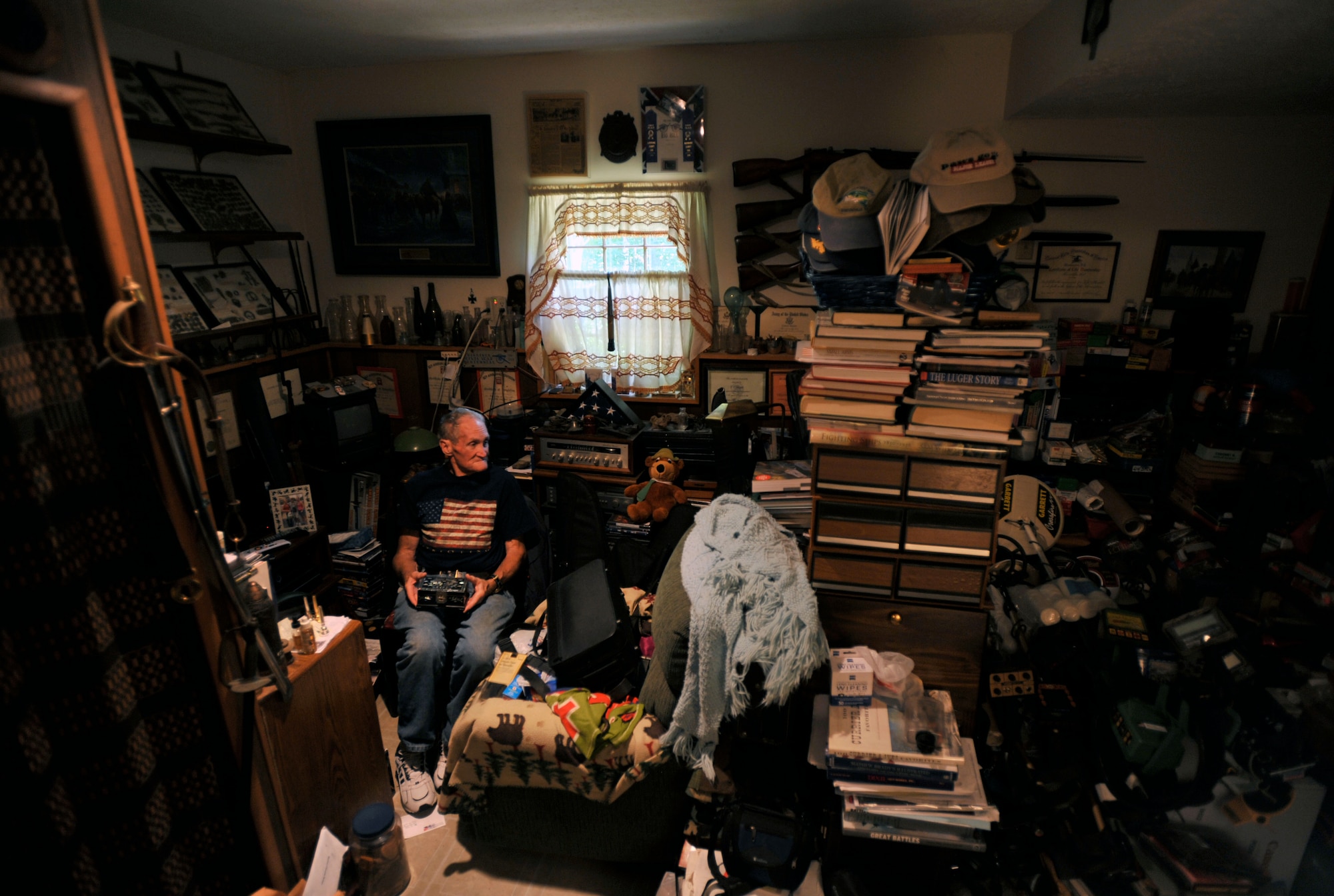 Retired U.S. Army Maj. E. Vernon Smith Jr. sits in his home in central Virginia among his collection of books, cameras and military memorabilia, July 20, 2013. Smith was stationed roughly 15 miles south of 38th parallel in Korea in support of the Korean Armistice Agreement signed July 27, 1953, ending the war between North and South Korea. (U.S. Air Force photo by Staff Sgt. Katie Gar Ward/Released) 