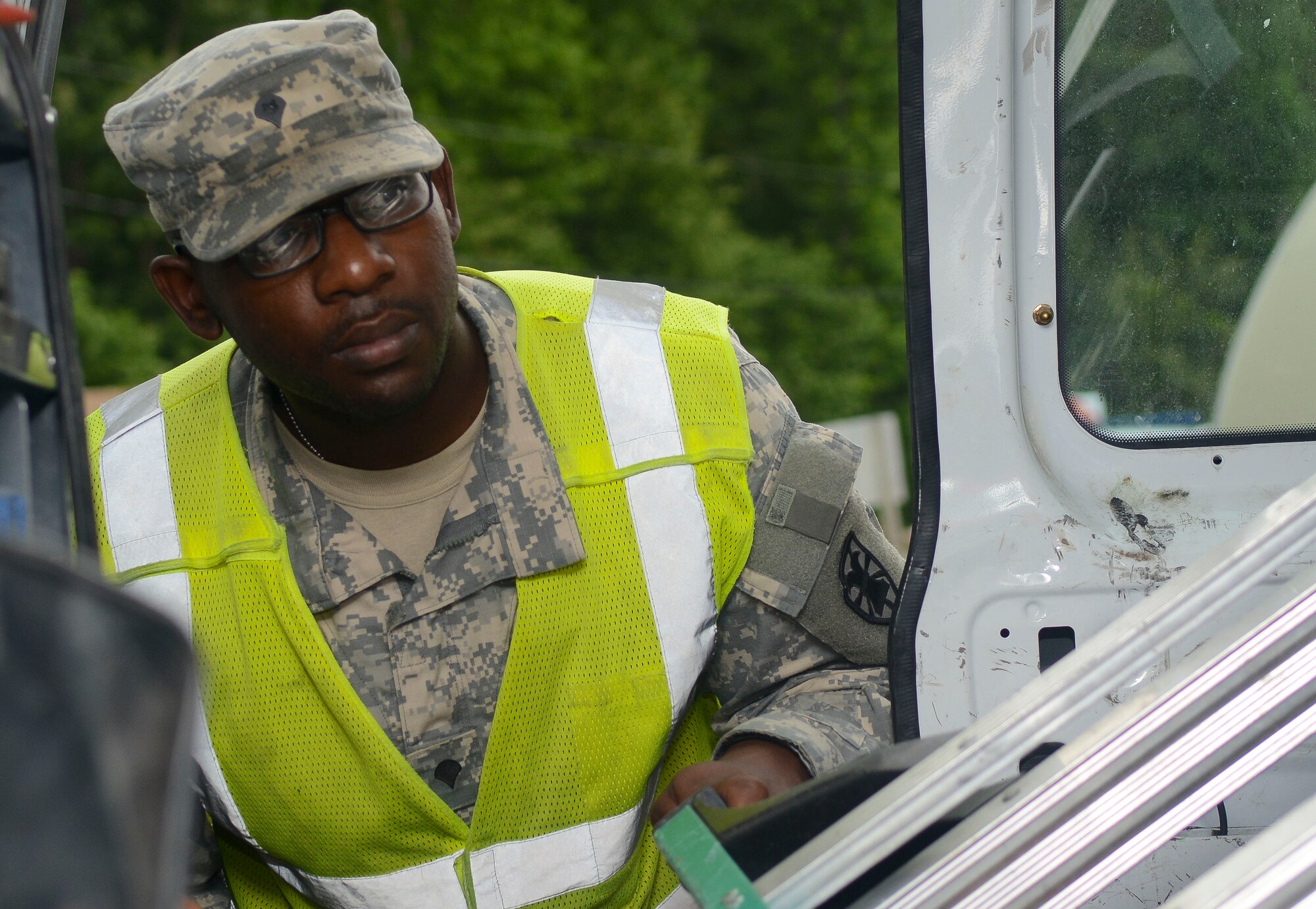 U.S. Army Spc. Sakeem Capers, 7th Sustainment Brigade gate guard augmentee, checks a utility van at Fort Eustis, Va., July 11, 2013. Authorized personnel are allowed to enter Fort Eustis after they go through an inspection if they do not have an approved ID. (U.S. Air Force photo by Airman 1st Class Austin Harvill/Released)