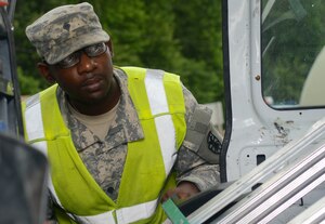 U.S. Army Spc. Sakeem Capers, 7th Sustainment Brigade gate guard augmentee, checks a utility van at Fort Eustis, Va., July 11, 2013. Authorized personnel are allowed to enter Fort Eustis after they go through an inspection if they do not have an approved ID. (U.S. Air Force photo by Airman 1st Class Austin Harvill/Released)