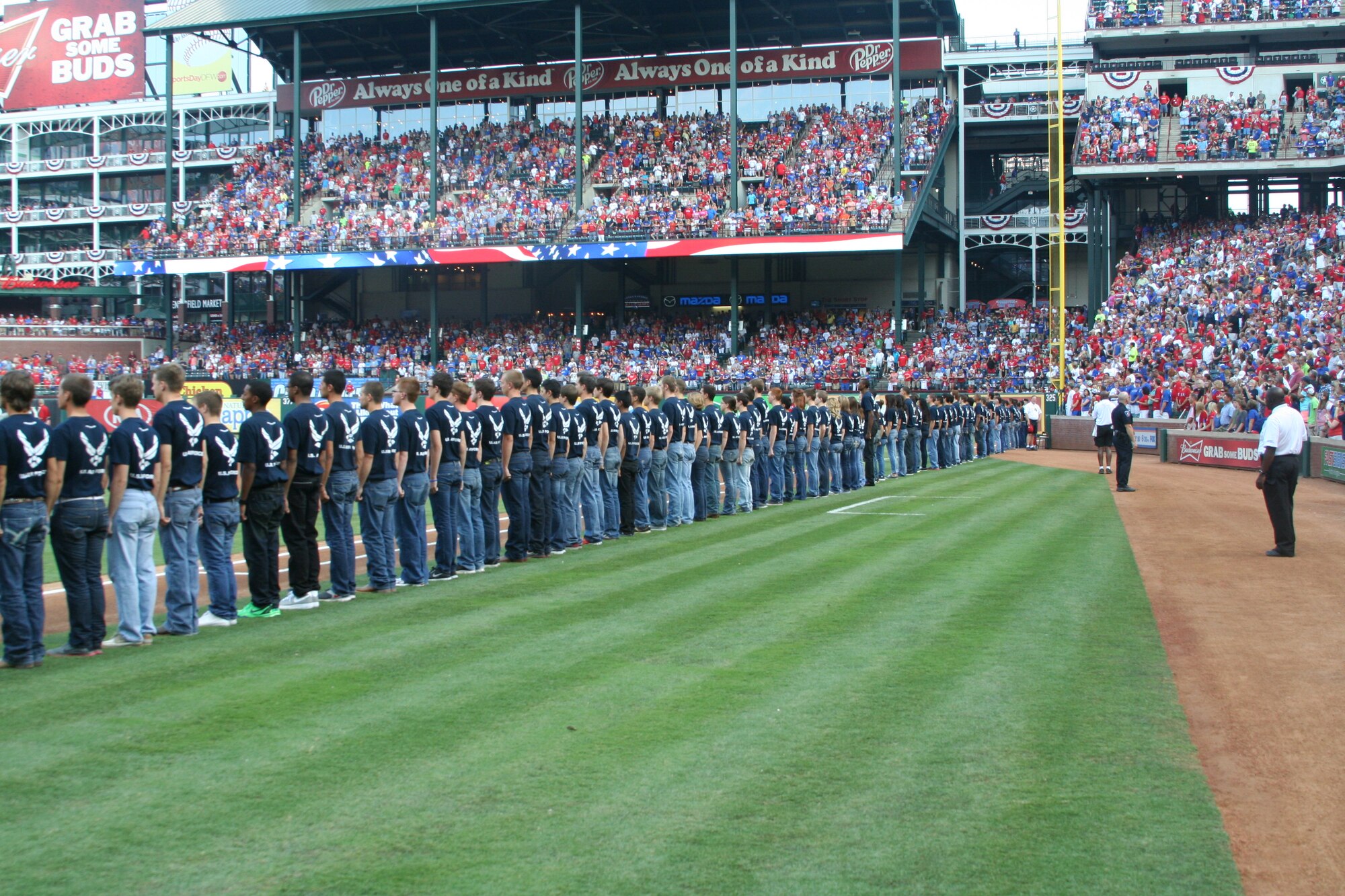 One hundred sixty-eight Air Force Delayed Entry Program members line up on the first and third base lines at the Texas Randers game in Arlington, Texas July 4. The DEP members took the oath of enlistment in a pregame ceremony. (U.S. Air Force photo/Staff Sgt. Cameron Wiley)