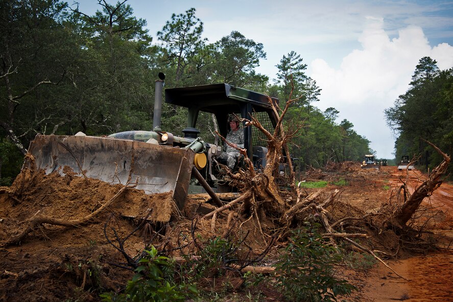 A Soldier, from the 877th Engineering Battalion from Alabama National Guard, uses a bulldozer to clear away debris to widen Range Road 219 July 22 at Eglin Air Force Base, Fla.  The Army unit deployed to Eglin for eight days to work on four range projects.  Soldiers used heavy equipment to widen RR 220 and 219 from one lane to two to allow for safe passage of Humvees and other armored vehicles.  The Army completed the project that began at Duke Field and ended at the Naval School of Explosive Ordnance Disposal in only six days.  The work on all four projects saved Eglin approximately $176,000.  (U.S. Air Force photo/Samuel King Jr.)