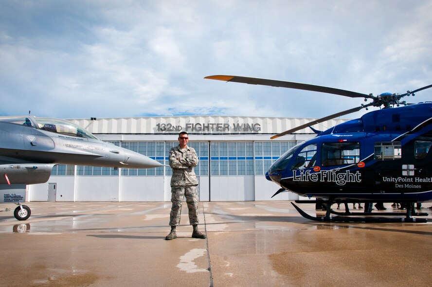 Master Sgt. Matthew Hand, crewchief, poses for a photo op alongside his dedicated jet (87-230), and UnityPoint Health's Life Flight Helicopter, in front of the main hangar at the 132nd Fighter Wing (132FW), Des Moines, Iowa, on July 19, 2013.  (U.S. Air National Guard photo by Senior Airman Dustin M. Smart/Released)