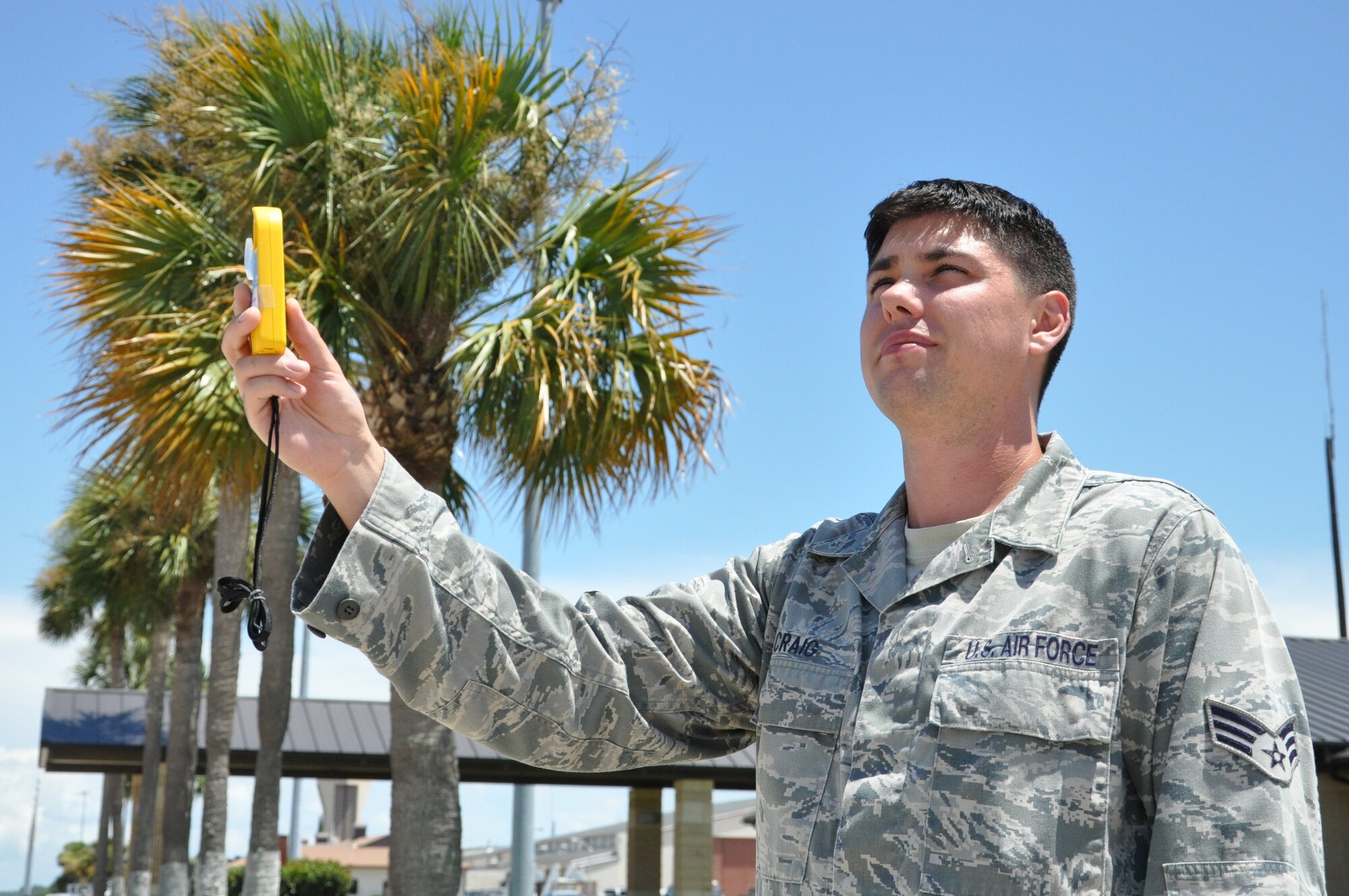 Senior Airman Jason Craig, 325th Operation Support Squadron Weather Flight weather technician, uses a handheld weather tracker July 2 outside the Tyndall Base Operations building. The weather tracker displays information such as temperature, wind speed and humidity, which allows the user to gauge weather trends. (U.S. Air Force photo by Airman 1st Class Alex Echols)
