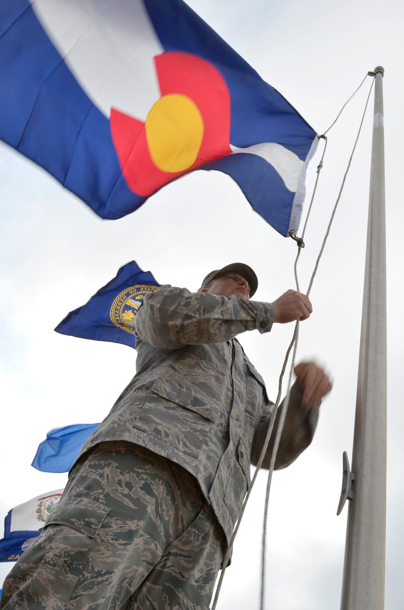 MCGHEE TYSON AIR NATIONAL GUARD BASE, Tenn. – Master Sgt. Jonathan Liermann lowers the state flag of the 38th U.S. state to join the union in 1876, Colorado, as he helps replace a display of state flags here, July 18, 2013. Every six months, Airmen from the I.G. Brown Training and Education Center meet on the parade ground to take down and replace the flags. (U.S. Air National Guard photo by Master Sgt. Kurt Skoglund/Released)