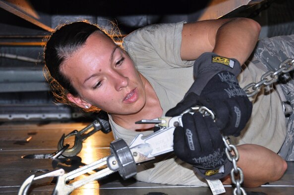 Tech Sgt. Jessica Caldwell from Consequence Management Team of the Texas Air National Guard secures a trailer with a hook and chain on a 433rd Airlift Wing C-5 A Galaxy.  The team, part of the Expeditionary Medical System, usually drives to disaster areas but were trained by the 433rd Airlift Control Flight on loading, securing and unloading their equipment from a 433rd Airlift Wing C-5. (U.S. Air Force Photo by Tech. Sgt. Carlos Trevino)
