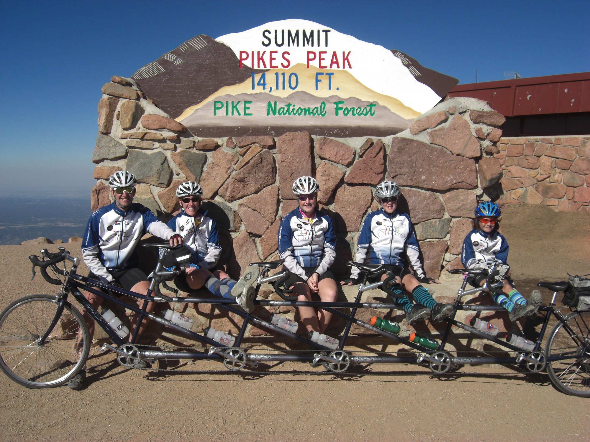 PETERSON AIR FORCE BASE, Colo.—Lt. Col. James Lawrence, a pilot with the 200th Airlift Squadron Colorado Air National Guard, and his family take a well-deserved rest at the summit of Pikes Peak after pedaling their way up on the family’s “quint” bicycle. For the Lawrence family, riding bikes of all shapes and sizes has become a passion. (Courtesy photo)