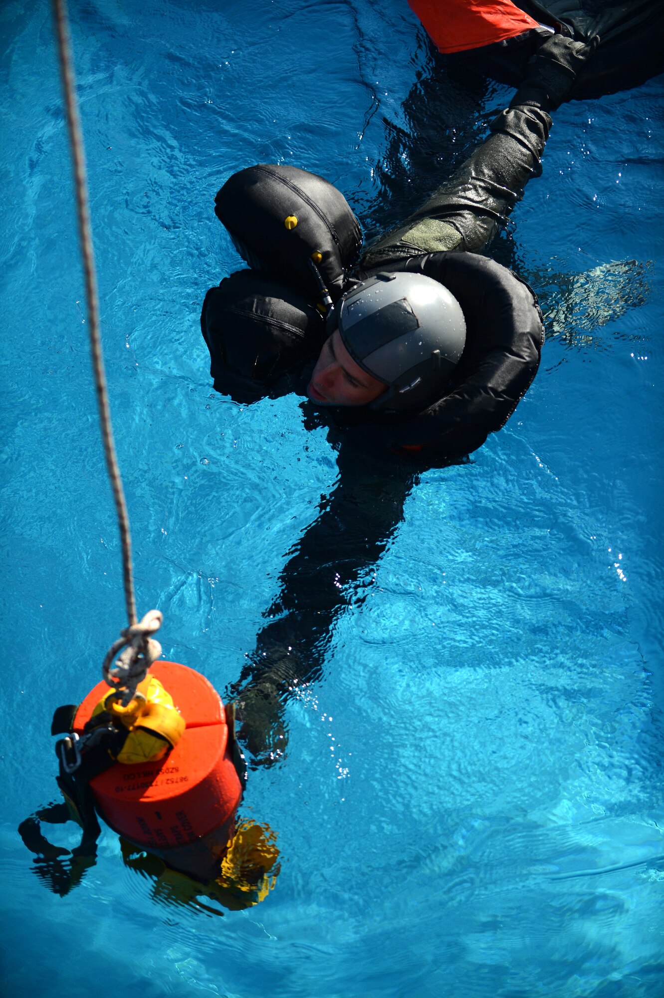 SPANGDAHLEM AIR BASE, Germany – U.S. Air Force Staff Sgt. David Wiggins, 52nd Operations Support Squadron NCO in charge of Survival, Evasion, Resistance and Escape training from Forsyth, Ga., swims toward a rescue recovery device during water survival training July 19, 2013. Pilots must be current on water survival training techniques in case they become injured during an aircraft bailout. (U.S. Air Force photo by Airman 1st Class Gustavo Castillo/Released)