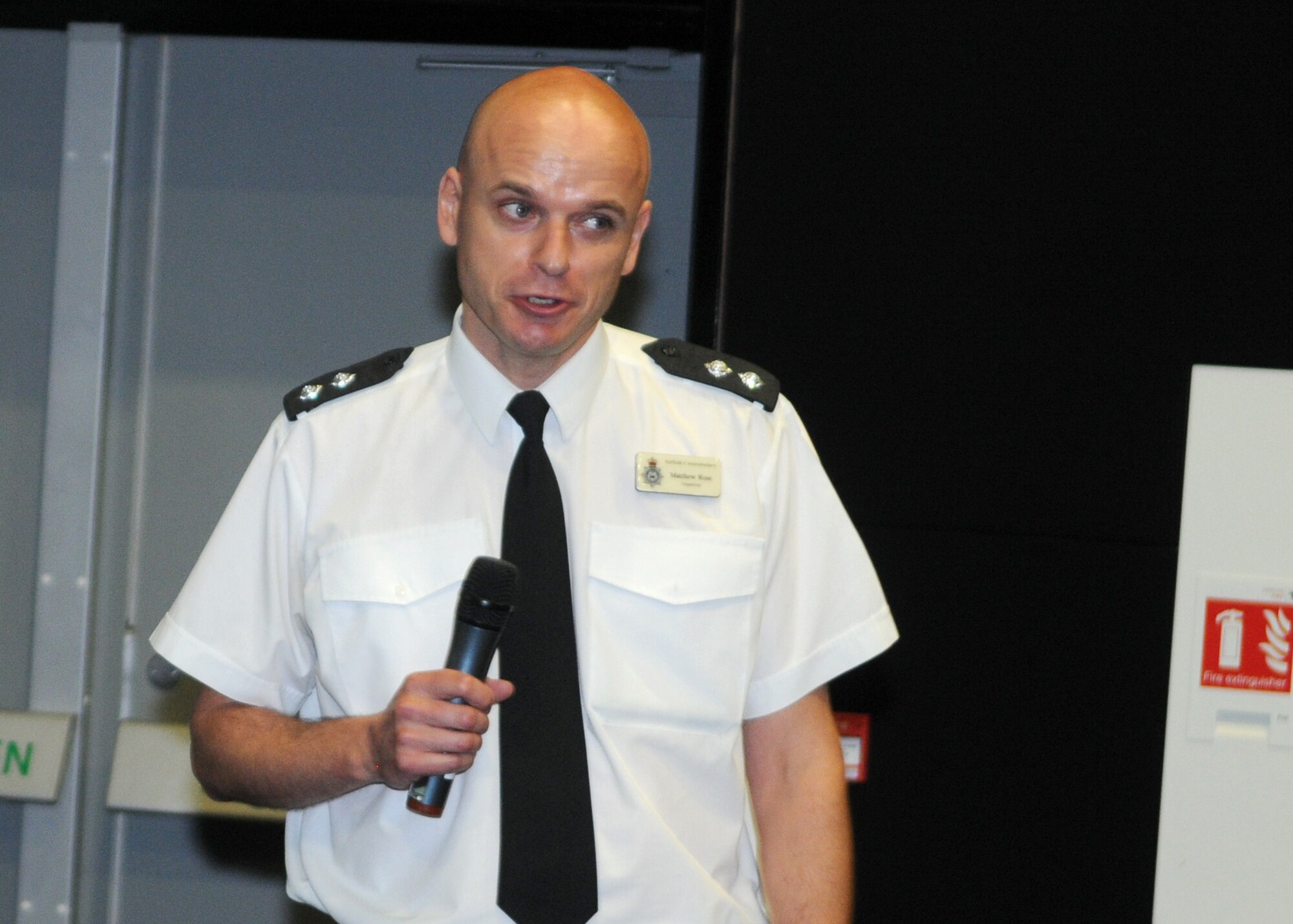 Inspector Matthew Rose, the Forest Heath District, Suffolk Constabulary, local policing commander, speaks to Airmen of the 100th Air Refueling Wing during a commander’s call July 23, 2013, at the base theater on RAF Mildenhall, England. Rose talked about the importance of securing homes and vehicles to prevent the theft of personal belongings. He elaborated how Americans are often victims of theft, not because they are simply Americans, but because they tend to leave their property unsecured, making it easy for an opportunistic criminals to carry out petty crimes. (U.S. Air Force photo by Staff Sgt. Tabitha M. Lee/Released)