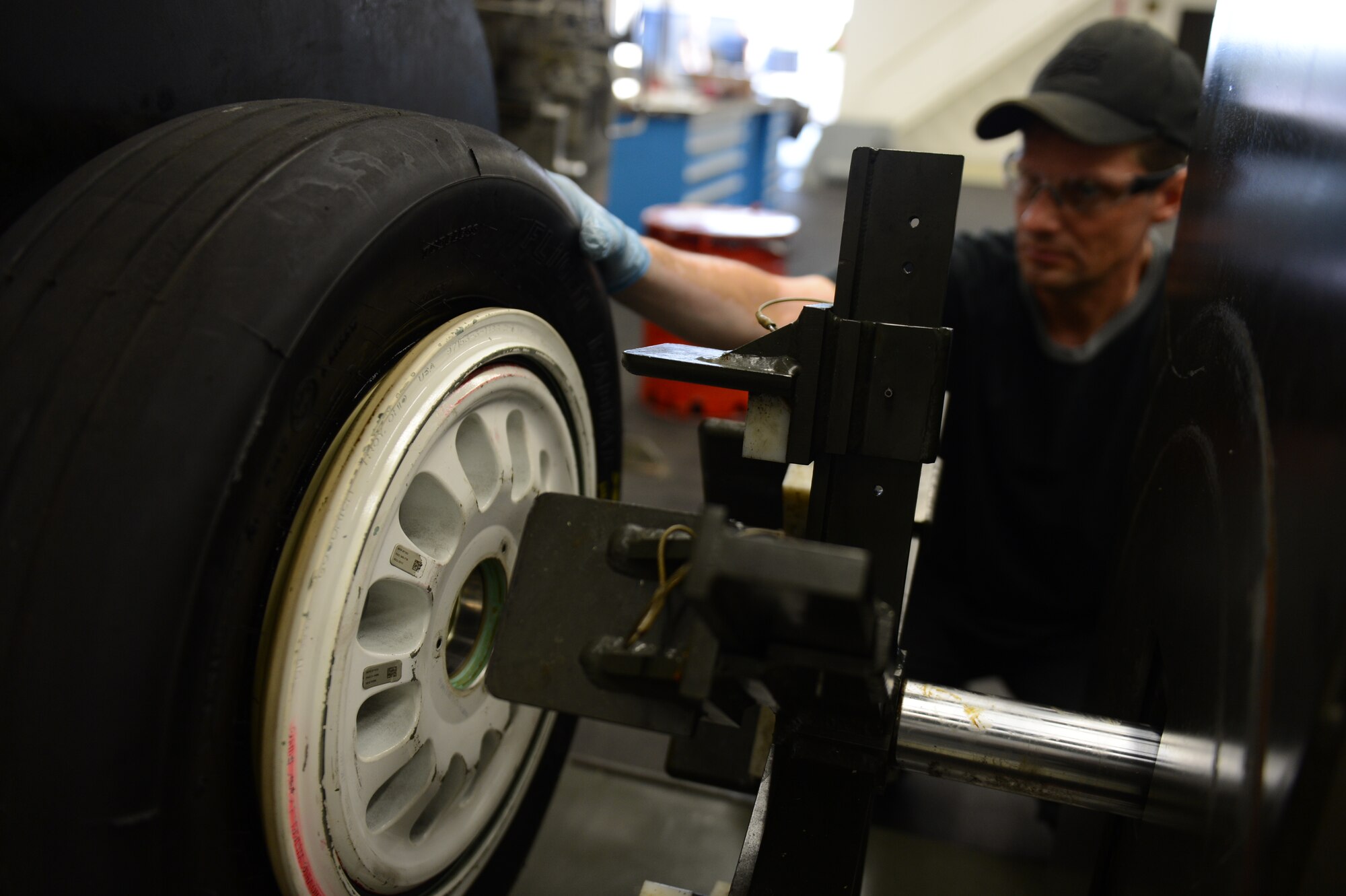 SPANGDAHLEM AIR BASE, Germany – Max Baer, 52nd Equipment Maintenance Squadron aircraft tire mounter from Dairyland, Wis., operates a tire mounting machine July 18, 2013.  The machine applies more than 15 tons of pressure to compress the tire while attaching the rim. (U.S. Air Force photo by Airman 1st Class Gustavo Castillo/Released) 