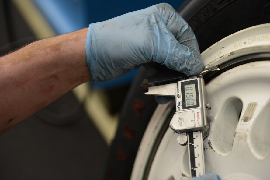 SPANGDAHLEM AIR BASE, Germany – Max Baer, 52nd Equipment Maintenance Squadron aircraft tire mounter from Dairyland, Wis., measures the outer retainer ring of an F-16 Fighting Falcon fighter aircraft July 18, 2013. The inner and outer retainer rings must be within a precise measurement to prevent the rim from collapsing inward. (U.S. Air Force photo by Airman 1st Class Gustavo Castillo/Released) 