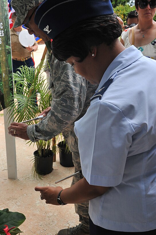 YIGO, Guam – Col. Kim Brooks, 36th Maintenance Group commander, lights a candle at the Caguas massacre memorial service in Yigo, Guam, July 17, 2013. Each lit candle signified one of the 45 native Chamorro men who were beheaded by the Japanese forces in July 1944 right before the liberation of Guam 69 years ago. (U.S. Air Force photo by Airman 1st  Class AdariusPetty/Released)
                                                                                                                                                                                                                                                                                                                                                                                                                                    