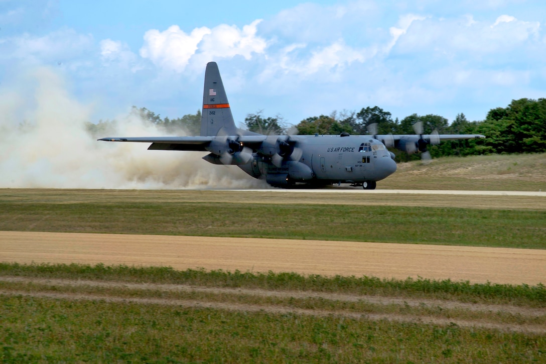 A C-130 Hercules aircraft lands on a dirt runway to support exercise ...