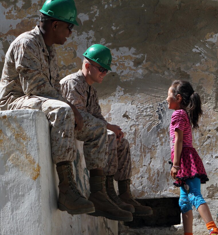 Staff Sgt. Antonio Tyler and 1st Lt. Matthew Elliott, project manager and officer-in-charge of Marines with 9th Engineer Support Battalion, 3rd Marine Logistics Group, joke with a local child during renovation work on Erdmiin Oyun High School as part of Exercise Khaan Quest in the Nalaikh District of Ulaanbaatar, Mongolia, July 23.  Khaan Quest is a regularly scheduled multinational exercise co sponsored this year by U.S. Marine Corps Forces, Pacific, and hosted annually by the Mongolian Armed Forces, designed to promote regional peace and security. 