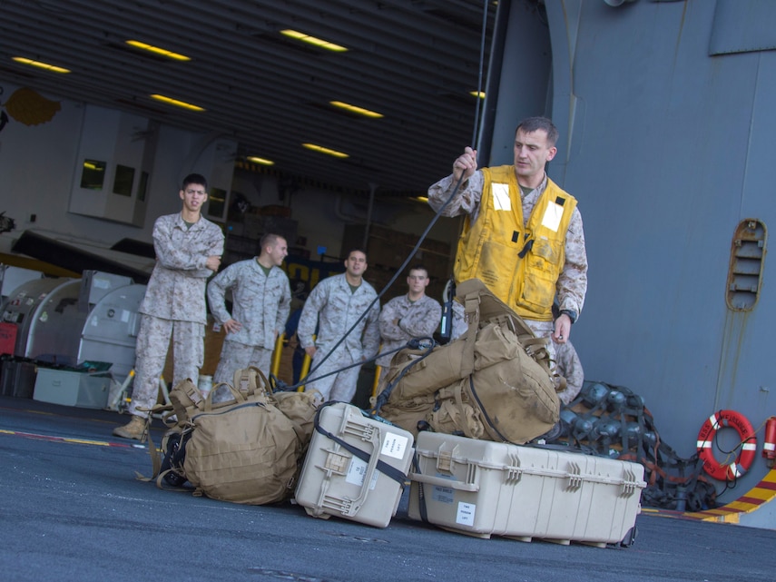 U.S. Marine Corps Gunnery Sgt. Paul Riley, a native of Philadelphia, and Combined Anti-Armor Team 1 platoon sergeant assigned to Battalion Landing Team 3/2, 26th Marine Expeditionary Unit (MEU), unhooks gear that was lowered using belaying techniques during high rope suspension training from a static MV-22B Osprey on the USS Kearsarge (LHD 3), July 23, 2013. The 26th MEU is a Marine Air-Ground Task Force forward-deployed to the U.S. 5th Fleet area of responsibility aboard the Kearsarge Amphibious Ready Group serving as a sea-based, expeditionary crisis response force capable of conducting amphibious operations across the full  range of military operations. (U.S. Marine Corps photo by Cpl. Kyle N. Runnels/Released