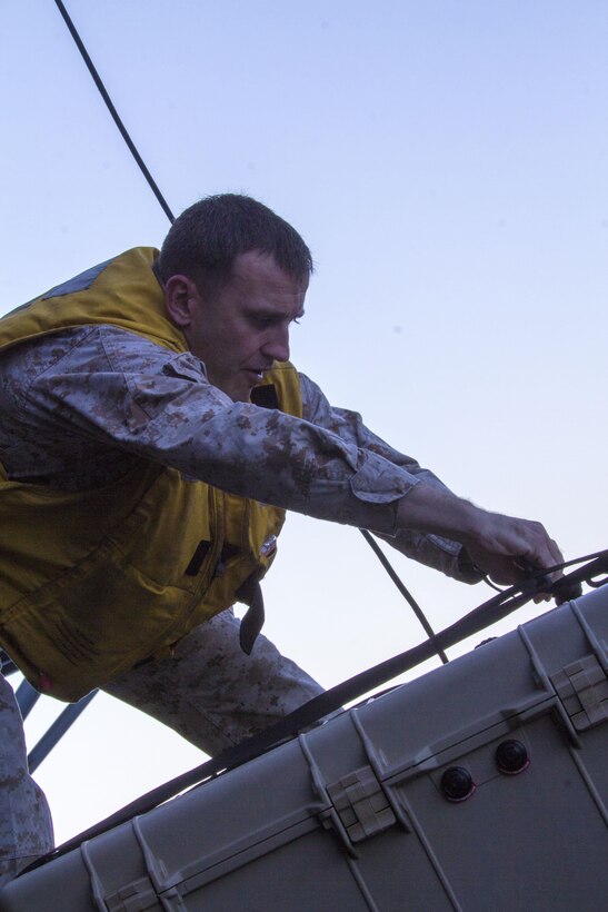 U.S. Marine Corps Gunnery Sgt. Paul Riley, a native of Philidelphia, and Combined Anti-Armor Team 1 platoon sergeant assigned to Battalion Landing Team 3/2, 26th Marine Expeditionary Unit (MEU), unhooks gear that was lowered using belaying techniques during high rope suspension training from a static MV-22B Osprey on the USS Kearsarge (LHD 3), July 23, 2013. The 26th MEU is a Marine Air-Ground Task Force forward-deployed to the U.S. 5th Fleet area of responsibility aboard the Kearsarge Amphibious Ready Group serving as a sea-based, expeditionary crisis response force capable of conducting amphibious operations across the full  range of military operations. (U.S. Marine Corps photo by Cpl. Kyle N. Runnels/Released