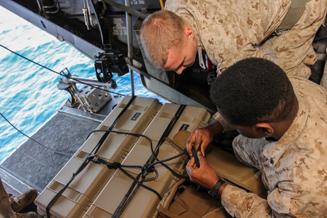 U.S. Marines assigned to Battalion Landing Team 3/2, 26th Marine Expeditionary Unit (MEU), tie knots while securing a pelican case to be belayed while conducting high rope suspension training in a static MV-22B Osprey on USS Kearsarge (LHD 3), at sea, July 23, 2013. The 26th MEU is a Marine Air-Ground Task Force forward-deployed to the U.S. 5th Fleet area of responsibility aboard the Kearsarge Amphibious Ready Group serving as a sea-based, expeditionary crisis response force capable of conducting amphibious operations across the full range of military operations. (U.S. Marine Corps photo by Sgt. Christopher Q. Stone, 26th MEU Combat Camera/Released)