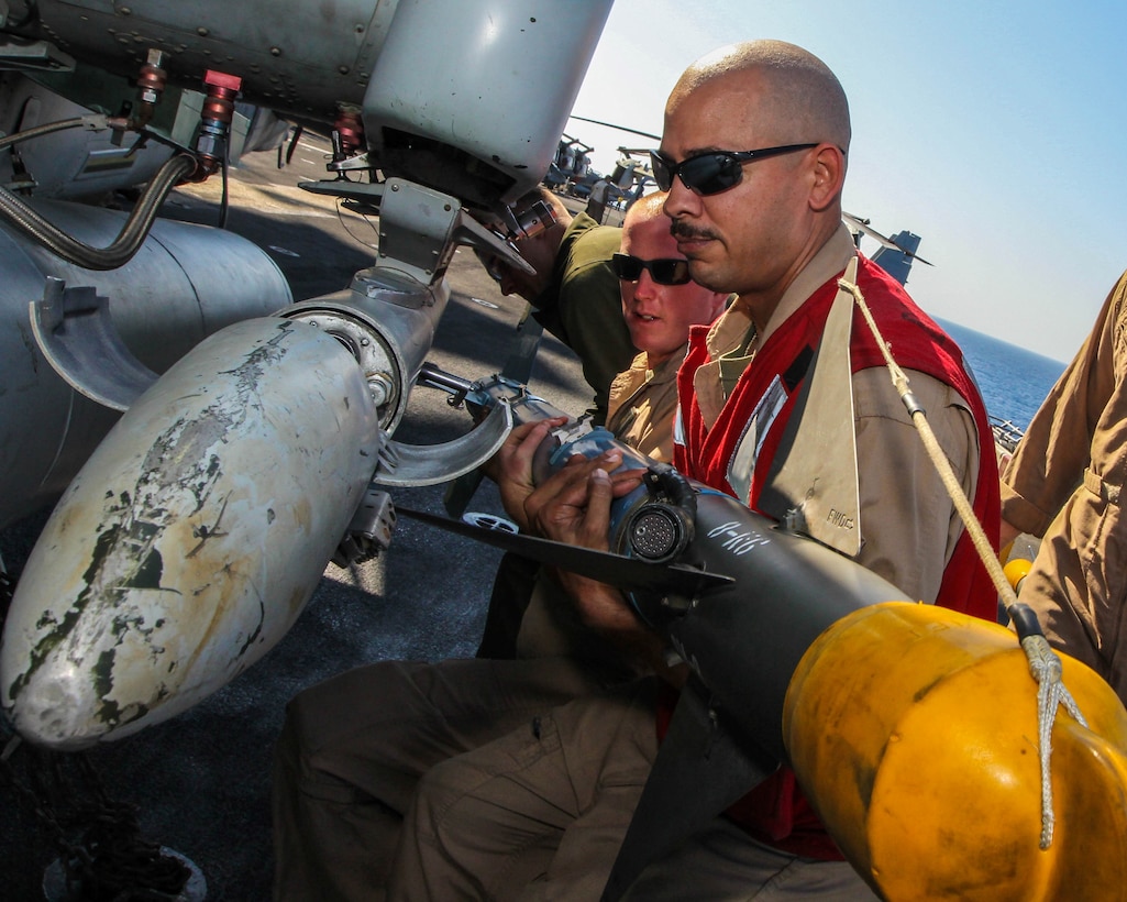 U.S. Marine Corps ordinance technicians attach an AIM-9 training rocket to an AH-1W Super Cobra assigned to Marine Medium Tiltrotor Squadron (VMM) 266 (Reinforced), 26th Marine Expeditionary Unit (MEU), on the flight deck of the USS Kearsarge (LHD 3), at sea, July 23, 2013. The 26th MEU is a Marine Air-Ground Task Force forward-deployed to the U.S. 5th Fleet area of responsibility aboard the Kearsarge Amphibious Ready Group serving as a sea-based, expeditionary crisis response force capable of conducting amphibious operations across the full range of military operations. (U.S. Marine Corps photo by Sgt. Christopher Q. Stone, 26th MEU Combat Camera/Released)