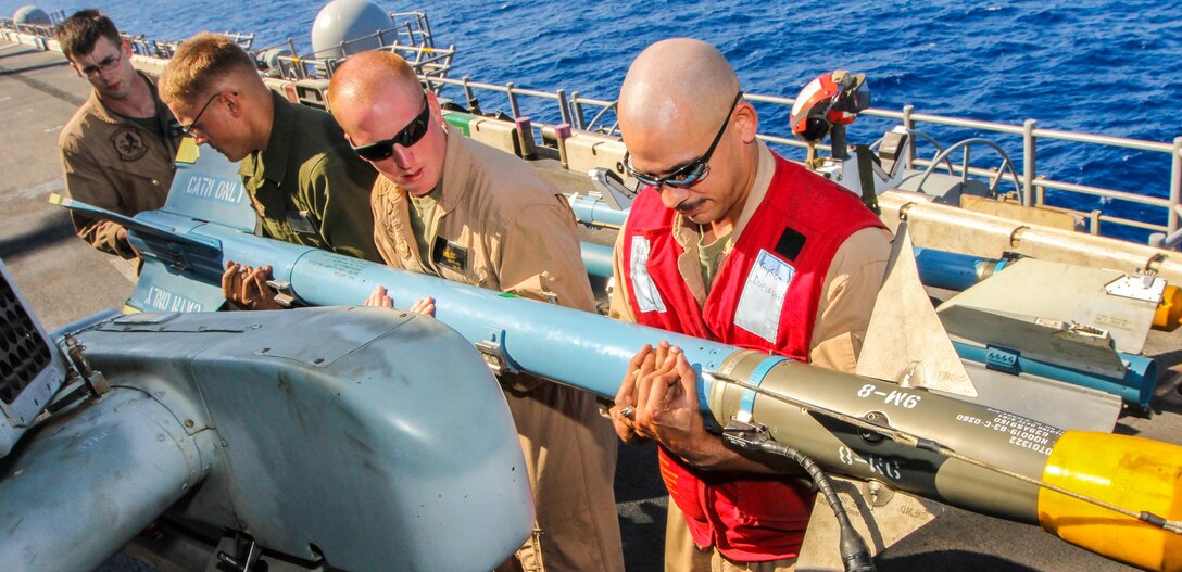 U.S. Marine Corps ordinance technicians attach an AIM-9 training rocket to an AH-1W Super Cobra assigned to Marine Medium Tiltrotor Squadron (VMM) 266 (Reinforced), 26th Marine Expeditionary Unit (MEU), on the flight deck of the USS Kearsarge (LHD 3), at sea, July 23, 2013. The 26th MEU is a Marine Air-Ground Task Force forward-deployed to the U.S. 5th Fleet area of responsibility aboard the Kearsarge Amphibious Ready Group serving as a sea-based, expeditionary crisis response force capable of conducting amphibious operations across the full range of military operations. (U.S. Marine Corps photo by Sgt. Christopher Q. Stone, 26th MEU Combat Camera/Released)