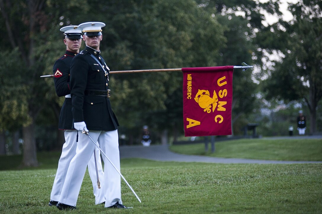 Capt. Tyler Tidwell, Marine Barracks Washington, D.C., Company A commander, and Lance Cpl. Tyler Thompson, A Co. guidon bearer, pass in review during a Tuesday Sunset Parade at the Marine Corps War Memorial in Arlington, Va., July 23.