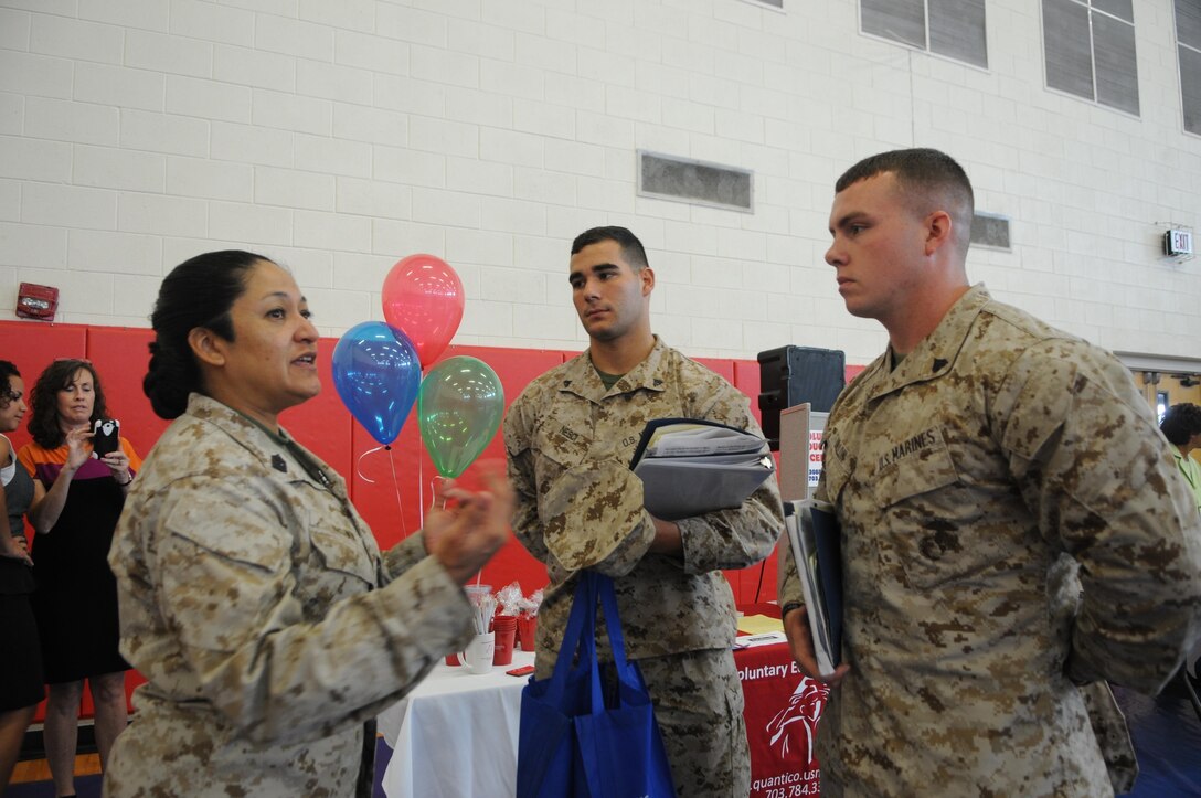 From left, Sgt. Maj. Laura Brown, the base sergeant major, welcomes Cpl. Daniel Nesci and Cpl. Stephen Dillon, both new to the base Motor Transport Branch, to Marine Corps Base Quantico at the monthly Welcome Aboard brief July 17. 