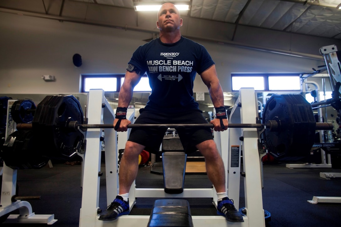 Staff Sgt. Matthew Reep, the assault chief for Division Schools, 1st Marine Division, adjusts the bar on a weightlifting bench at the Camp Margarita gym here, July 17, 2013. Reep, a native of Lexington, S.C., currently holds the world record for bench press in his weight class.