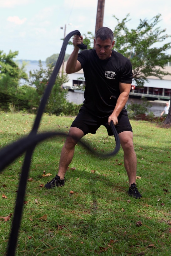 Dennis J. Yeddo, fitness facilities manager, fitness branch, Semper Fit division, Marine Corps Community Services performs rope battles during a Paddle Fit Boot Camp workout aboard Marine Corps Base Camp Lejeune, July 23. The workouts are first come, first serve courses.