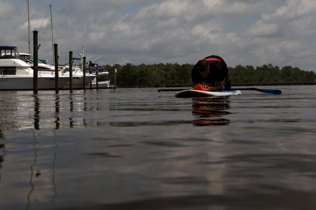 Dennis J. Yeddo, fitness facilities manager, fitness branch, Semper Fit division, Marine Corps Community Services performs planks on a paddleboard during a Paddle Fit Boot Camp workout aboard Marine Corps Base Camp Lejeune, July 23. Participants can call ahead for preregistration or register and pay at the Outdoor Adventures office at the Gottschalk Marina aboard base.