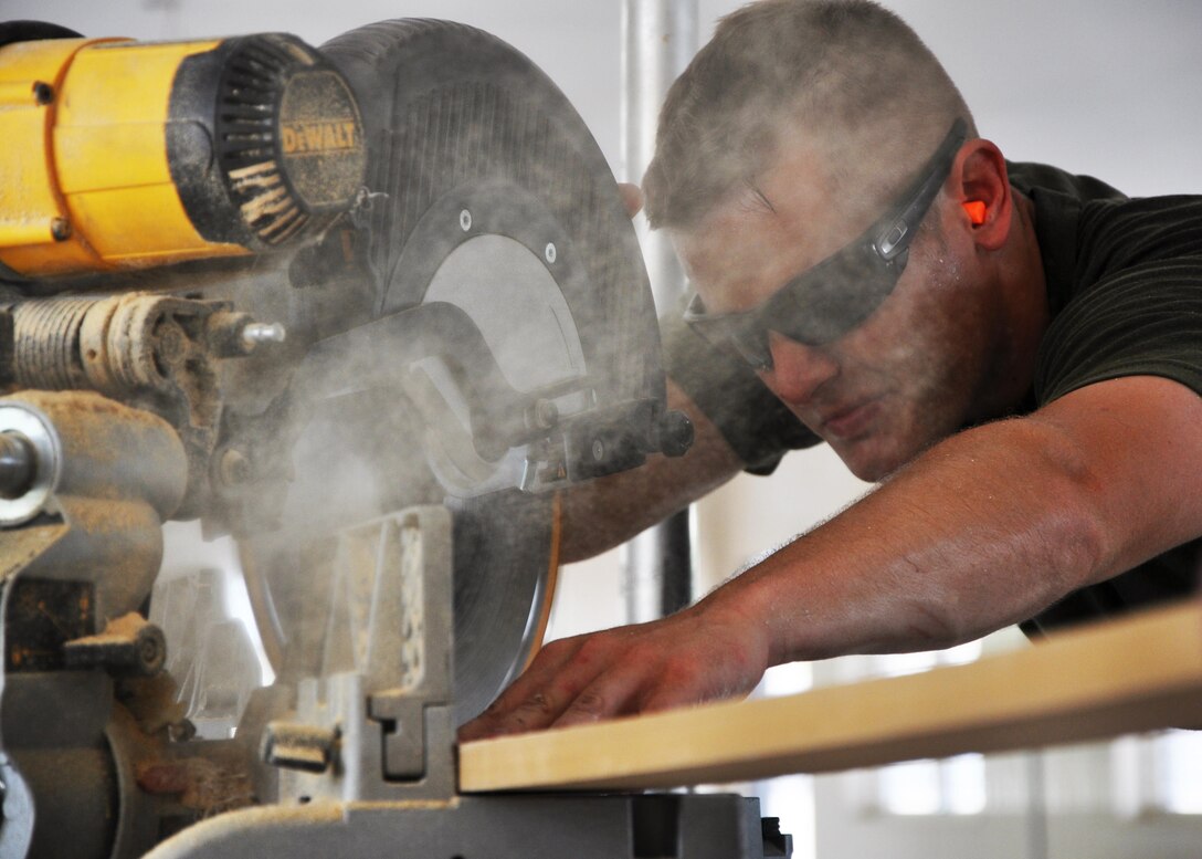 U.S. Marine Corps Cpl. Brett Harden, a combat engineer from Marine Wing Support Squadron 471, cuts a piece of wood at Crooked Tree Government Primary School, May 29.  Engineers from both the U.S. and Belize are constructing various structures at schools throughout Belize as part of exercise New Horizons. (U.S. Air Force photo by Capt. Holly Hess/Released)