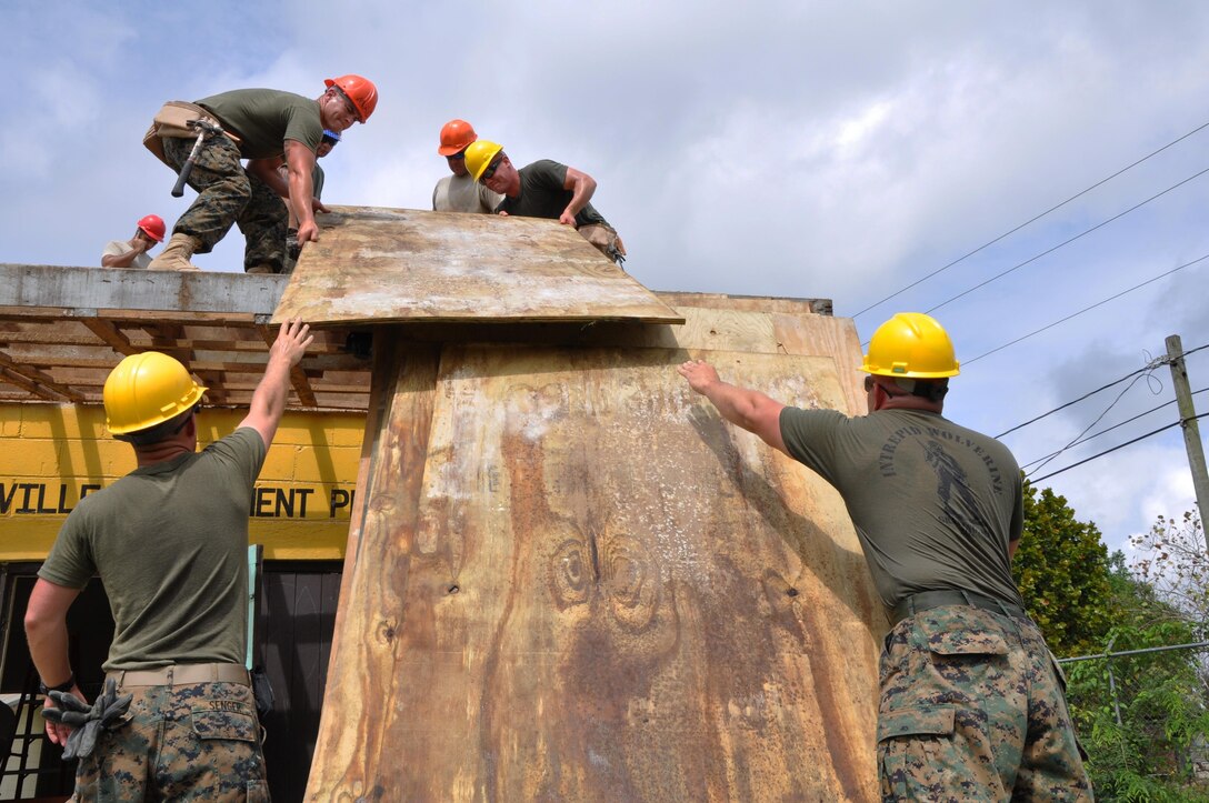 HATTIEVILLE, Belize— U.S. Marine Corps combat engineers lift roof decking at Hattieville Government Pre-School to repair the structure, June 4.  Engineers from both the U.S. and Belize are constructing various structures at schools throughout Belize as part of exercise New Horizons. (U.S. Air Force photo by Capt. Holly Hess/Released)
