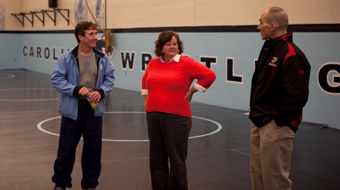 Conrad Mock Jr., coach of the University of North Carolina at Chapel Hill’s wrestling team, greets Brig. Gen. Thomas Gorry commanding general for Marine Corps Installations East – Marine Corps Base Camp Lejeune and his wife Kim, prior to Military Appreciation Night at the school Feb. 8. Gorry was invited to the appreciation night to be recognized for his induction into the wrestling hall of fame for outstanding achievements. Mock and Gorry wrestled together while they both attended UNC. 