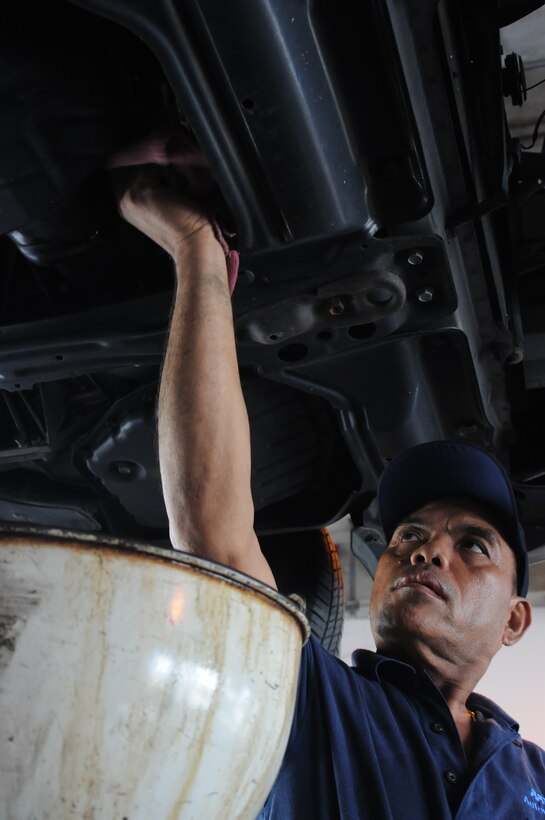 Jimmy Mendoza, Army and Air Force Exchange Service Car Care Center auto technician, tightens a bolt into an engine July 19, 2013 on Andersen Air Force Base, Guam. AAFES technicians recommend that filters and oil be changed every 3,000 miles or every three months to ensure a vehicle continues running well. (U.S. Air Force photo by Airman 1st Class Amanda Morris/Released)