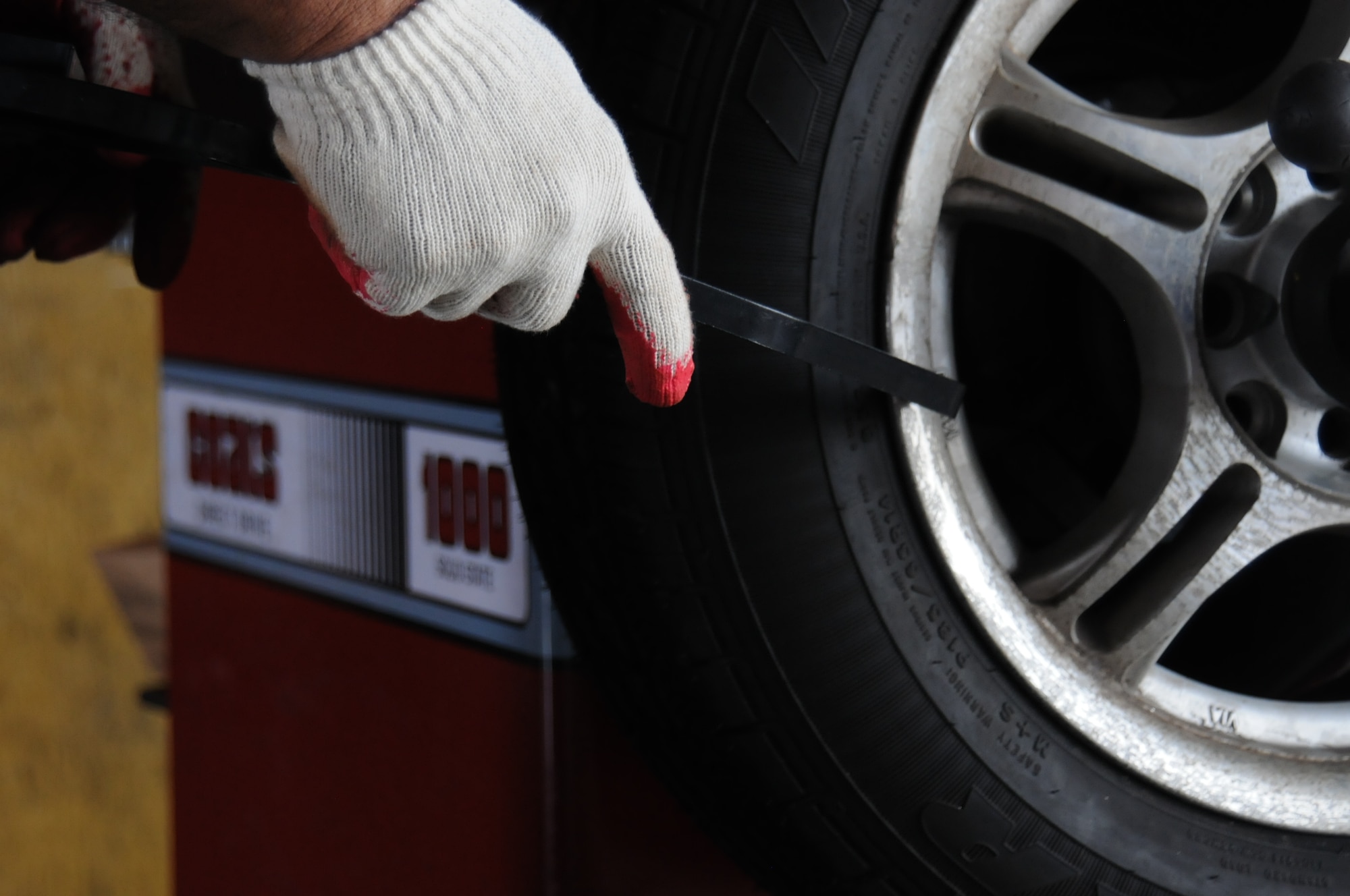 Jimmy Mendoza, Army and Air Force Exchange Service Car Care Center auto technician, measures the width of a tire July 19, 2013 on Andersen Air Force Base, Guam. Technicians convert the measurements to weight before using the tire-balancing machine. (U.S. Air Force photo by Airman 1st Class Amanda Morris/Released)
