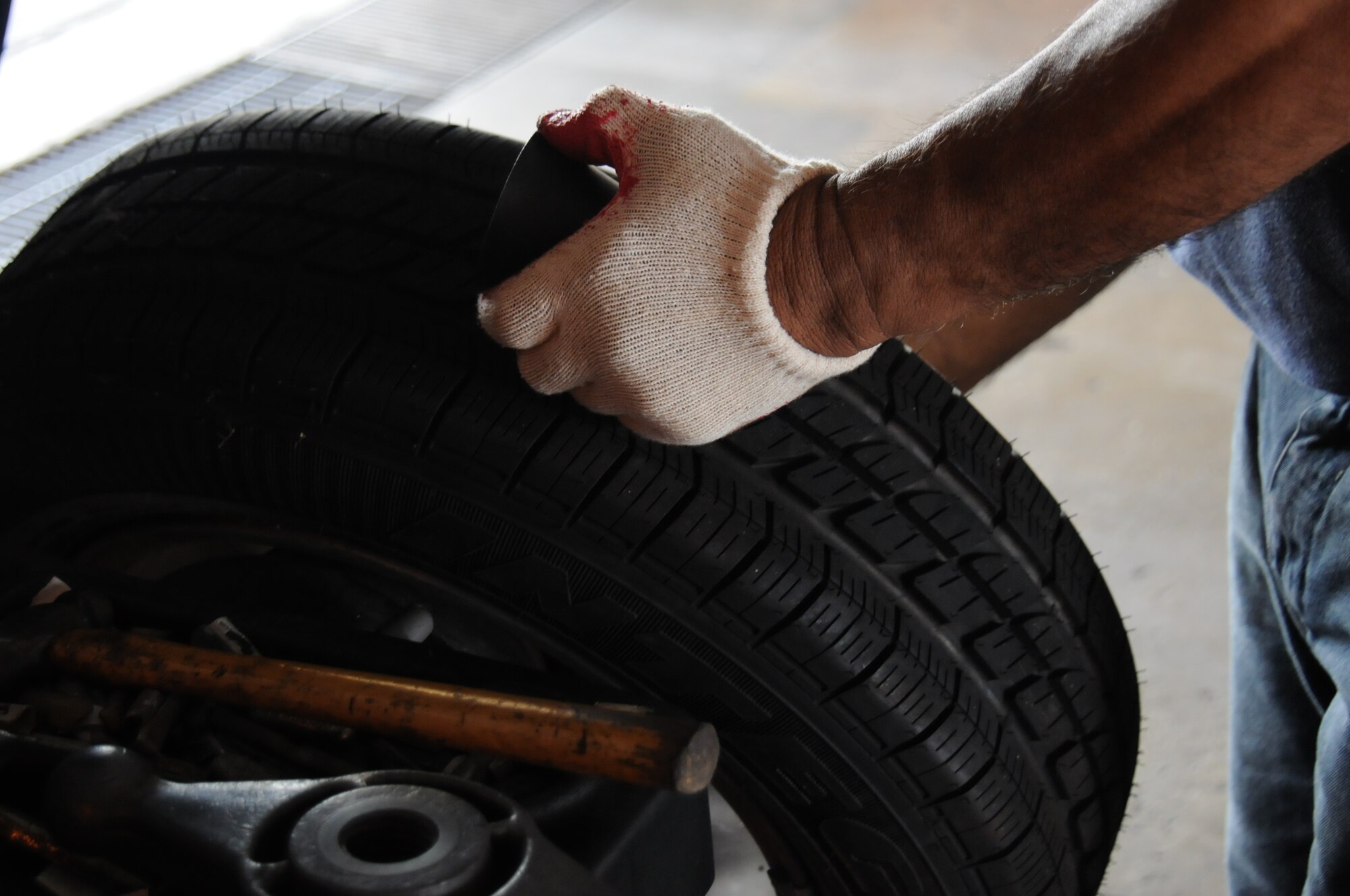 Jimmy Mendoza, Army and Air Force Exchange Service Car Care Center auto technician, tightens a wheel on a tire-balancing machine July 19, 2013 on Andersen Air Force Base, Guam. The machine tests tire vibrations during maintenance. (U.S. Air Force photo by Airman 1st Class Amanda Morris/Released)