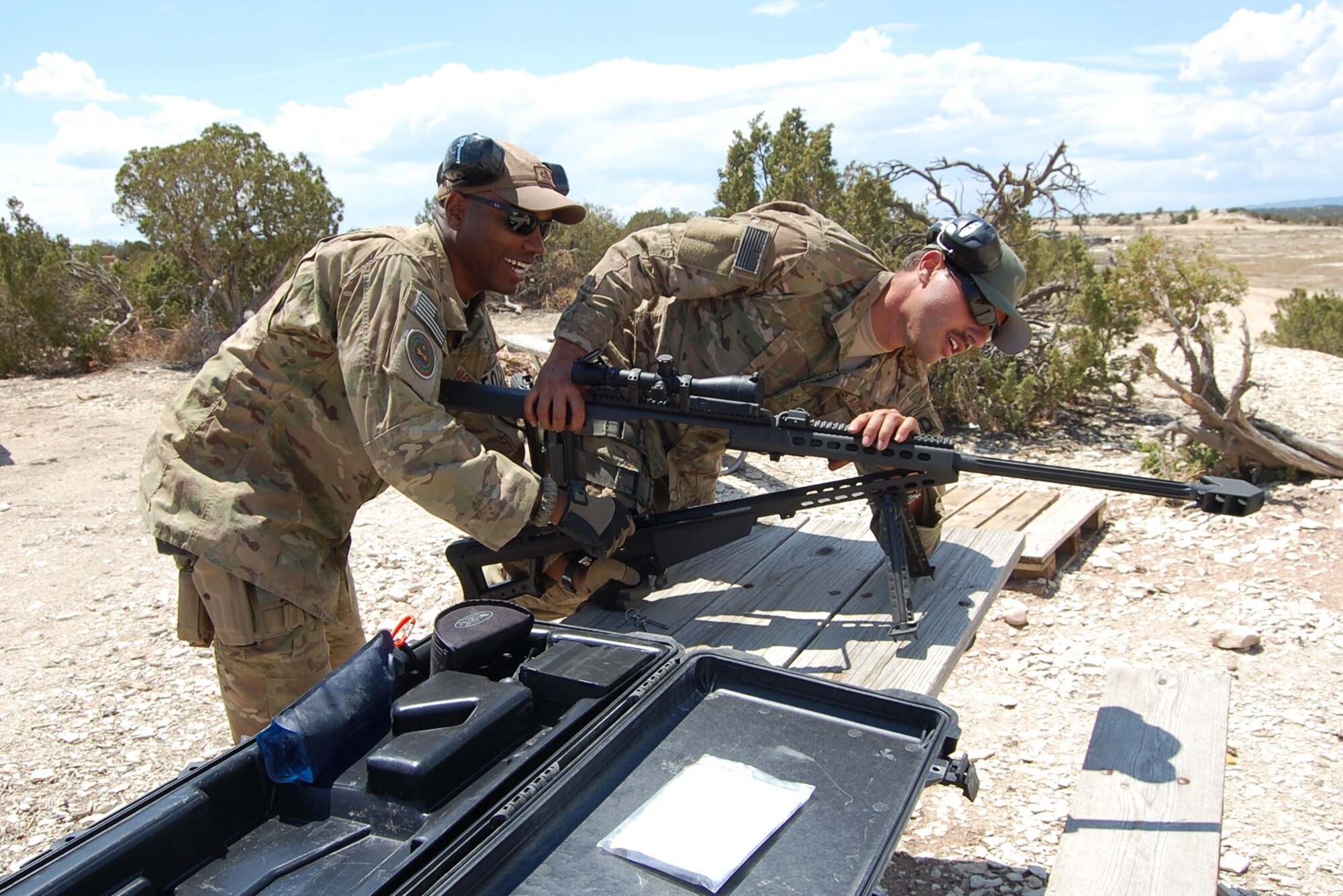 Colorado Air National Guard Staff Sgt. Christopher Broyles and Airman 1st Class Darrell Linkus, 140th Explosive Ordnance Disposal Flight, work together to set up a 50 caliber rifle during the EOD Demo Day July 12, 2013 at Airburst Range, Fort Carson, Colo. as part of their routine training requirements. (U.S. Air National Guard photo by Capt. Kinder Blacke)