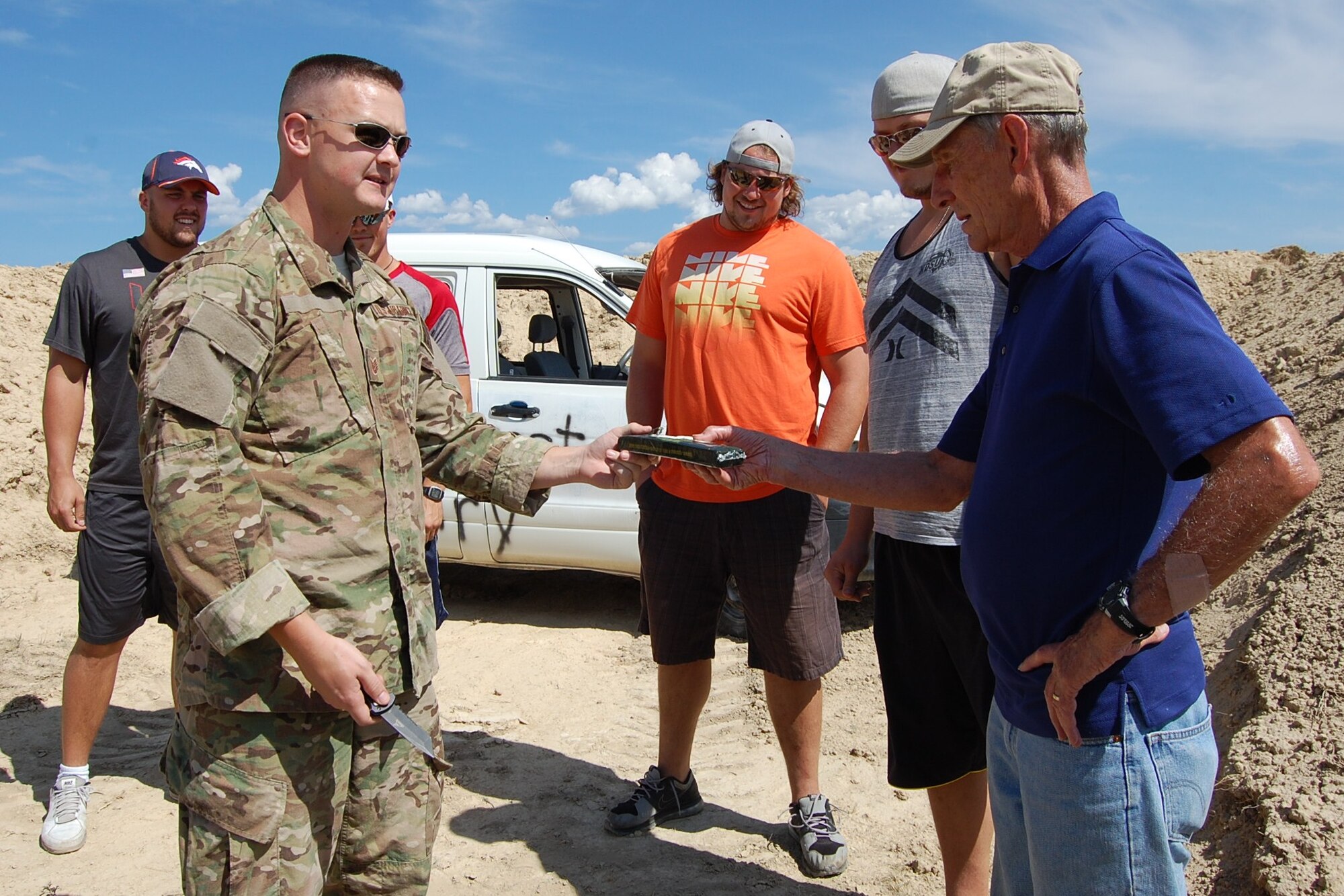 Colorado Air National Guard Tech. Sgt. Andrew LeBeau, 140th Explosive Ordnance Disposal Flight, shows Col. (ret) Hugh Garland a block of C4, a highly explosive material, during the EOD Demo Day July 12, 2013 at Airburst Range, Fort Carson, Colo. (U.S. Air National Guard photo by Capt. Kinder Blacke)