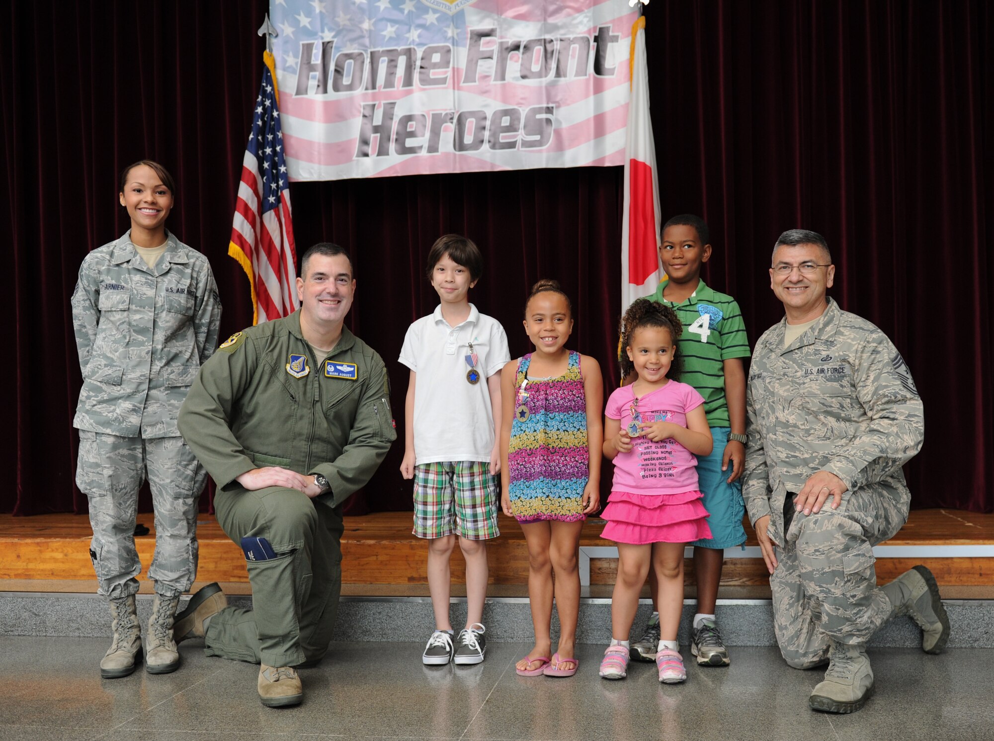 YOKOTA AIR BASE, Japan -- Recipients of the Home Front Hero award stand with wing leadership during an award ceremony at Yokota Air Base, Japan, July 22, 2013. The ceremony recognized the children for their outstanding conduct and sacrifices made while their parents were deployed. (U.S. Air Force photo by Senior Airman Andrea Salazar)