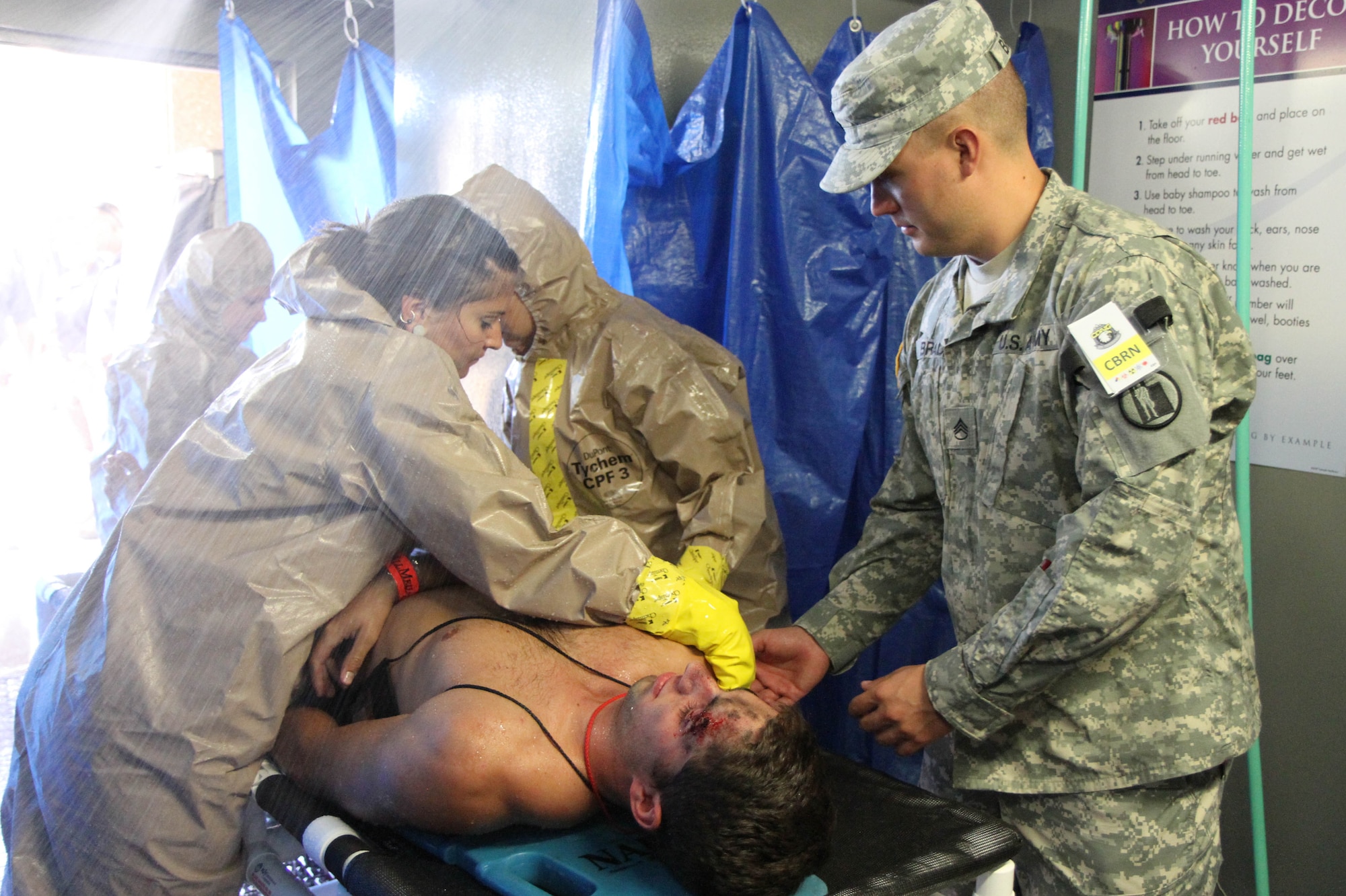 U.S. Army Staff Sgt. Jeff Brady, (right) decontamination readiness noncommissioned officer with the 115th Maintenance Company, Utah National Guard, assists emergency room nurses at Exempla St. Joseph Hospital with decontaminating a mock victim during a natural-disaster training scenario decontamination exercise, at Exempla St. Joseph Hospital in Denver, Colo., July 23, 2013, as part of the 2013 Vigilant Guard exercise. Vigilant Guard, hosted by the Colorado National Guard, is a large-scale, multi-state, multi-agency exercise focused on inter-agency coordination in preparation for emergencies and catastrophic events in Colorado. (U.S. Army National Guard photo by Spc. Zach Sheely)