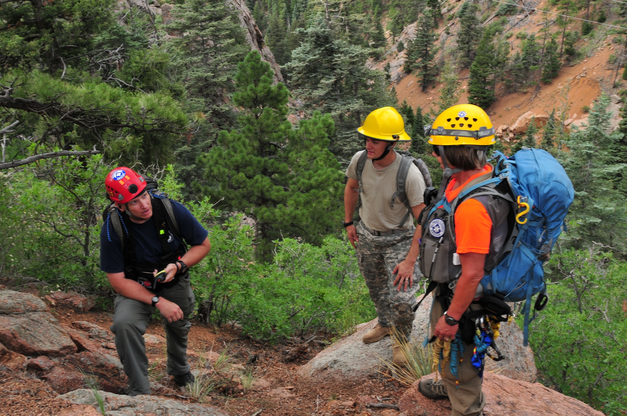 El Paso County Search and Rescue member Eric Babcock (left) talks with fellow team members Patty Baxter (right) and U.S. Army Staff Sgt. Matthew Wimmer, 1157th Engineer Firefighting Company, Colorado National Guard, while performing a simulated search and rescue mission at the U.S. Air Force Academy in Colo. Springs, Colo., during a Vigilant Guard exercise, July 22, 2013. The Vigilant Guard exercise is a weeklong exercise full of scenarios based on wildfires, tornadoes, air craft accidents, hazmat response, search and rescue, triage, medevac and other emergency-response measures. The training and experience gained from this exercise will provide the Colorado National Guard and supporting military units an opportunity to improve cooperation and operational relationships with their local, state, private sector, non-governmental organizations and federal partners. (U.S. Air National Guard photo by Tech. Sgt. Wolfram M. Stumpf)
