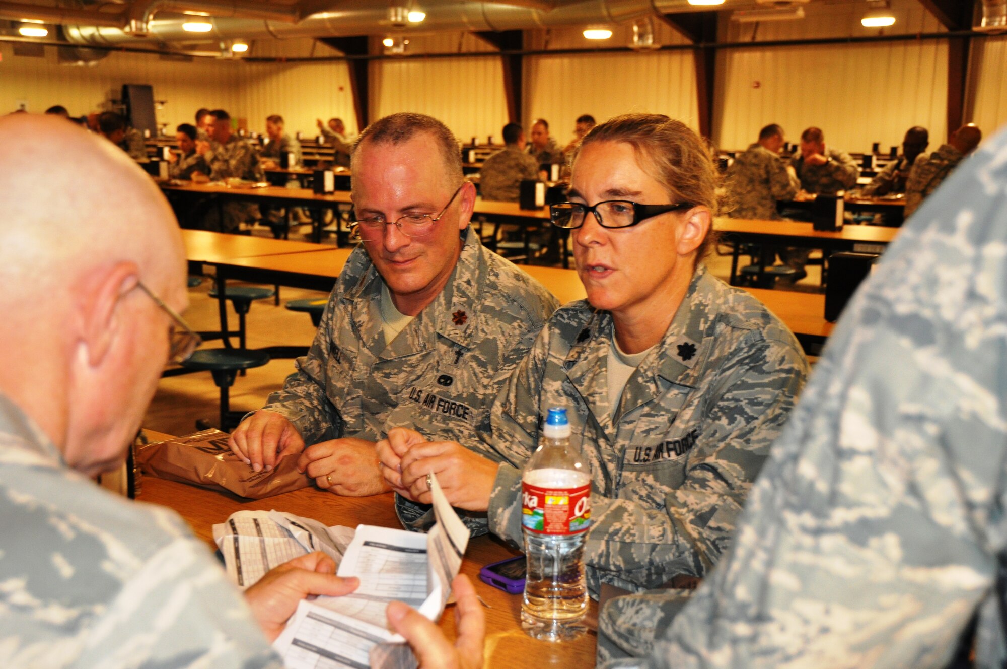 Chaplain (Lt. Col.) Lucinda Valenti (right), 433rd Airlift Wing, reviews the itinerary for chaplain candidates with Chaplain (Maj.) Stephen Sowell, 502nd Air Base Wing, as the candidates and basic trainees have a lunch of Meals Ready to Eat here July 24.  The candidates had a chance to see basic trainees rescue a wounded warrior and go through an obstacle course. (Air Force photo by Tech Sgt. Carlos Trevino)