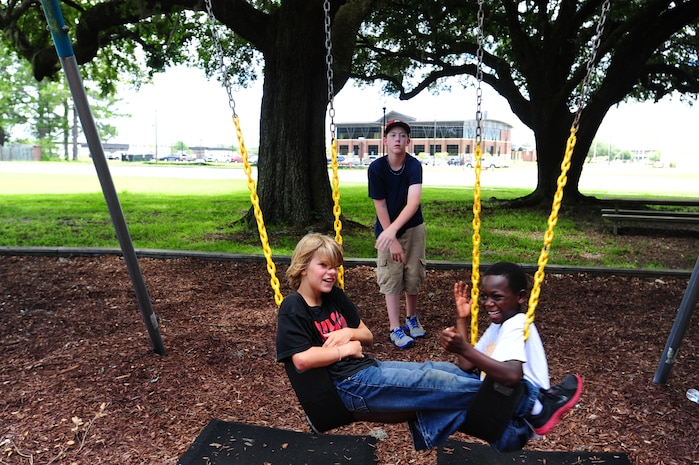 Children from the Eagle Harbor Boys Ranch enjoy the swings during a visit July 22, 2013, at Joint Base Charleston – Air Base, S.C. The boys watched a K-9 demonstration and were able to examine the 628th Security Forces Squadron patrol cars. The 628th Civil Engineer Squadron Fire Department also briefed the children about their jobs as firefighters and gave them a tour of the fire station. (U.S. Air Force photo/ Staff Sgt. David Collins )
