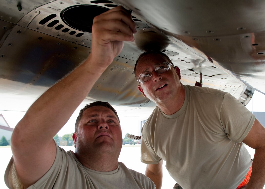 U.S. Air Force Master Sgt. Bruce Hartke(right) and Senior Airman Charles Loeffler (left), 125th Figther Wing, crew chiefs adjust a screw on an F-15 Eagle, during the Trident Warrior 2013 exercise at Langley Air Force Base, Va., July 18, 2013. Pilots from various U.S. Air Force and Navy units participated in the exercise over the Atlantic Ocean near the Hampton Roads, Va., area, July 8-19. (U.S. Air Force photo by Staff Sgt. John D. Strong II / Released)