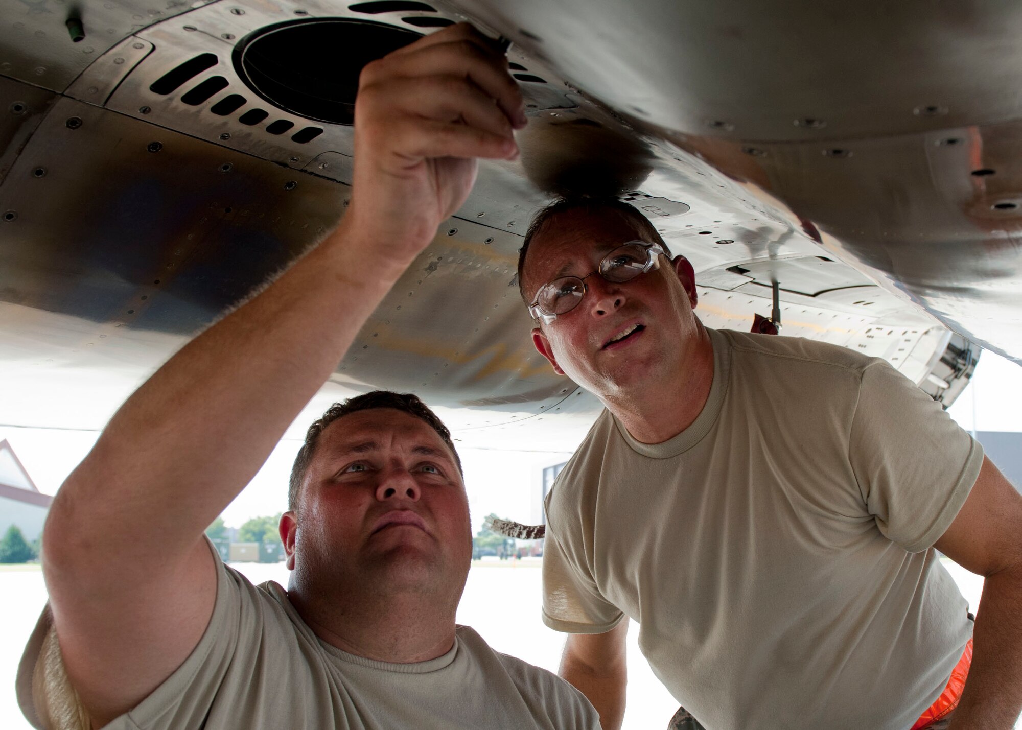 U.S. Air Force Master Sgt. Bruce Hartke(right) and Senior Airman Charles Loeffler (left), 125th Figther Wing, crew chiefs adjust a screw on an F-15 Eagle, during the Trident Warrior 2013 exercise at Langley Air Force Base, Va., July 18, 2013. Pilots from various U.S. Air Force and Navy units participated in the exercise over the Atlantic Ocean near the Hampton Roads, Va., area, July 8-19. (U.S. Air Force photo by Staff Sgt. John D. Strong II / Released)