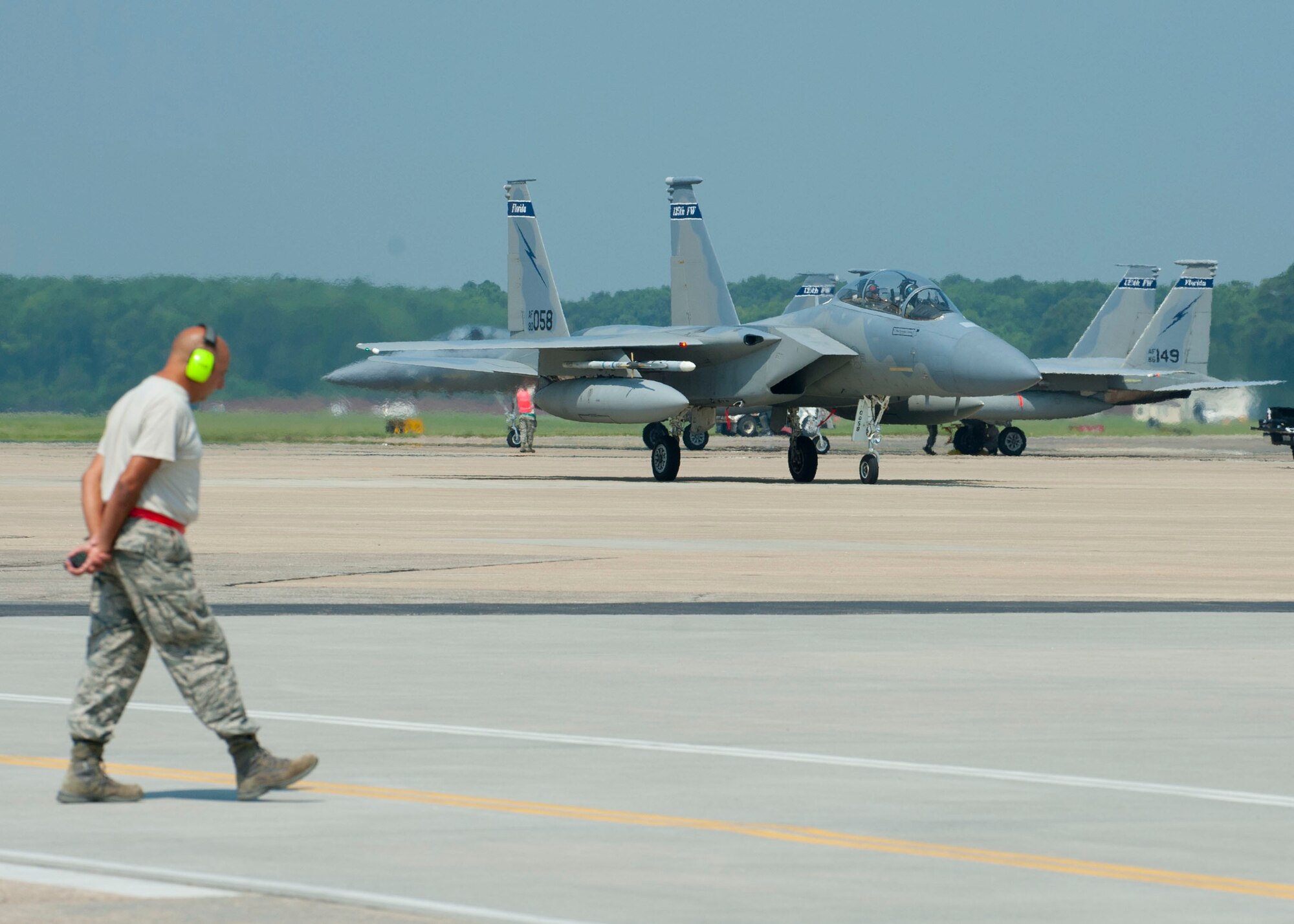 A U.S. Air Force crew chief from the 125th Fighter Wing, waits for an F-15 Eagle to taxi during the Trident Warrior exercise at Langley Air Force Base, Va., July 18, 2013.  During testing, the pilots were divided into two teams titled “Blue Force” and “Red Force,” in simulated aerial combat. (U.S. Air Force photo by Staff Sgt. John D. Strong II / Released)