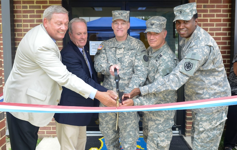 U.S. Army Maj. Gen. Bradley May, center, Initial Military Training Center of Excellence deputy commanding general, and members of the 733rd Mission Support Group officially open a new fitness facility during a ribbon-cutting ceremony at Fort Eustis, Va., July 24, 2013. The facility was built to accommodate personnel during the peak fitness hours in the morning and mid-day. (U.S. Air Force photo by Airman 1st Class Austin Harvill/Released)