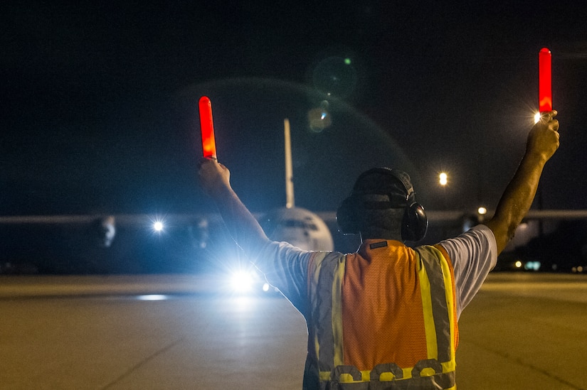 Wendell Speight, 437th Aircraft Maintenance Squadron aircraft servicer, marshals a C-130J-30 from Dyess Air Force Base, Texas, to takeoff after an early morning cargo load July 23, 2013, at Joint Base Charleston - Air Base, S.C. The C-130J-30 was loaded with rations and supplies bound for Bogota. The C-130J-30 is a stretch version of the C-130J, a proven, highly reliable and affordable airlifter. The C-130J-30 adds 15 feet to the fuselage, increasing usable space in the cargo compartment. (U.S. Air Force photo/ Senior Airman George Goslin)