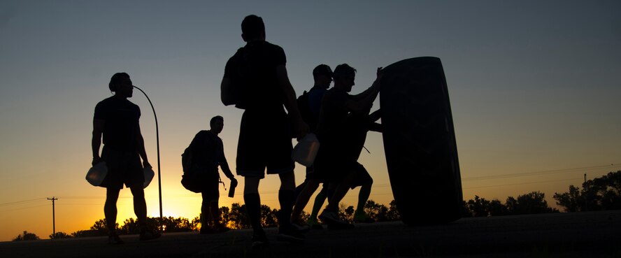Participants in the CrossFit challenge flip an 800-pound tire on July 13, 2013. The challenge was conducted to raise money for the Wounded Warrior Project through the Clebe McClary Association (U.S. Air Force photo/Senior Airman Brittany Y. Auld)