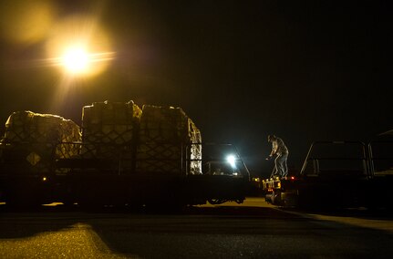 A civilian with the 437th Aerial Port Squadron directs a K-loader during an early morning cargo load July 23, 2013, at Joint Base Charleston - Air Base, S.C. The C-130J-30 was loaded with rations and supplies bound for Bogota. The C-130J-30 is a stretch version of the C-130J, a proven, highly reliable and affordable airlifter. The C-130J-30 adds 15 feet to the fuselage, increasing usable space in the cargo compartment. (U.S. Air Force photo/ Senior Airman George Goslin)