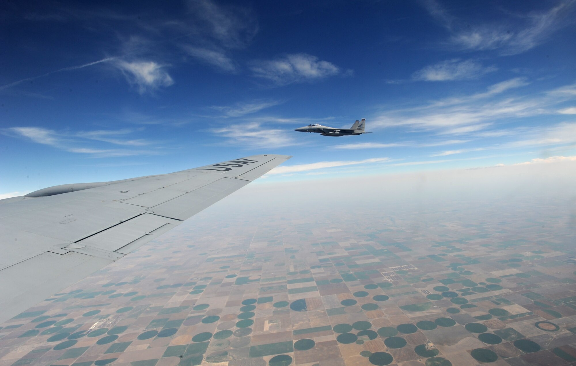 An F-15 Eagle from the 142nd Fighter Wing, Oregon Air National Guard, Portland, Ore., flies alongside a KC-135 Stratotanker assigned to McConnell Air Force Base, Kan., July 23, 2013. The F-15 was one of eight to receive fuel from three McConnell Total Force tankers during the training mission over northeast Kansas. (U.S. Air Force photo/Senior Airman Laura L. Valentine)