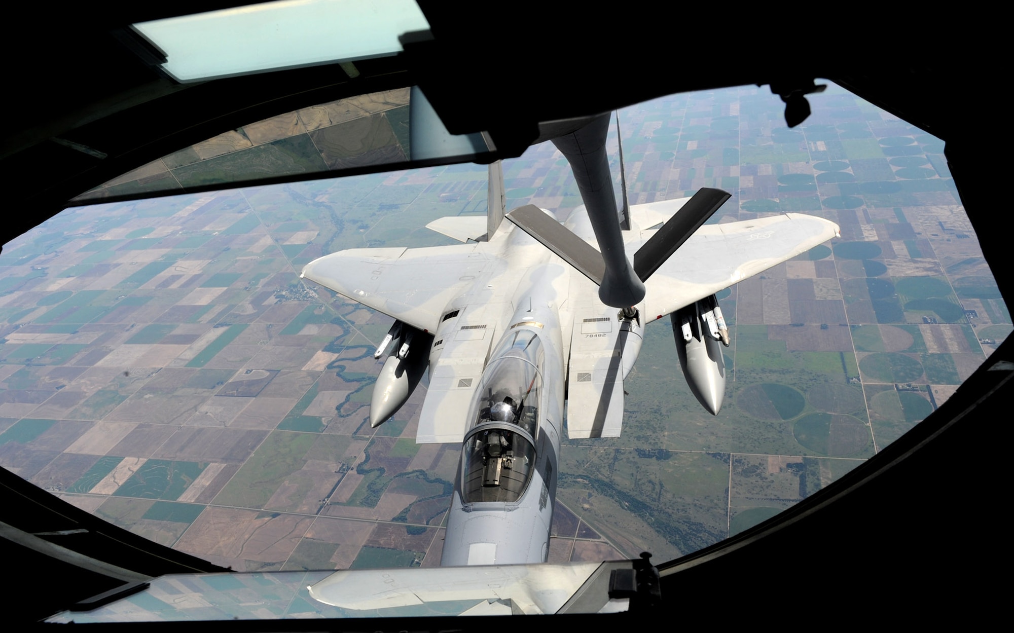 An F-15 Eagle from the 142nd Fighter Wing, Oregon Air National Guard, Portland, Ore., receives fuel from a KC-135 Stratotanker assigned to McConnell Air Force Base, Kan., over northeast Kansas July 23, 2013. Eight F-15s were refueled by three Stratotankers during the Total Force training mission. As an Air Mobility Command base, McConnell’s mission is to deliver total force mission ready Airmen and KC-135 mobility to combatant commanders anytime, anywhere.  (U.S. Air Force photo/Senior Airman Laura L. Valentine)